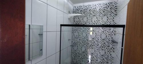 une salle de bain avec une douche avec une porte vitrée dans l'établissement Chácara paraíso, à Socorro