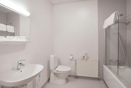 a white bathroom with a toilet and a sink at Hotel Menstrup Kro in Menstrup