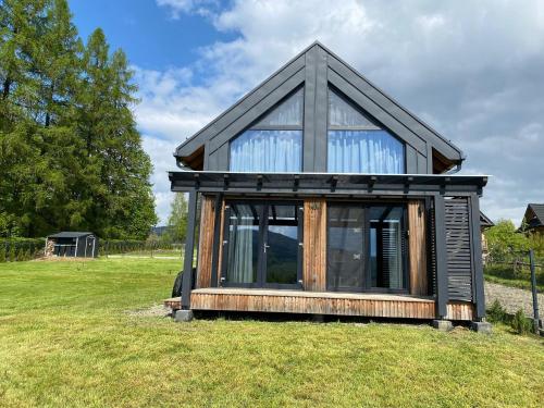 a small house sitting on top of a grass field at Love Wysove in Wysowa-Zdrój