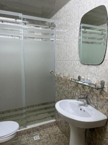 W łazience znajduje się szklana kabina prysznicowa i umywalka. w obiekcie Hotel Shakhname w Samarkandzie
