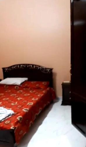 a bedroom with a bed with a red blanket at Jijel location F3 avec piscine plein air in Jijel