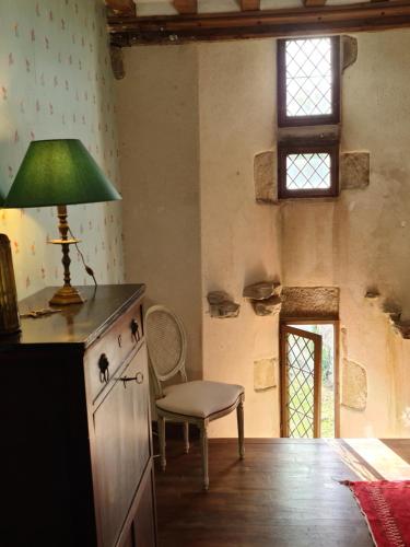 une cuisine avec une chaise et une lampe sur un comptoir dans l'établissement Prieuré saint Léonard, XIème siècle, Baie du mont saint Michel, à Vains