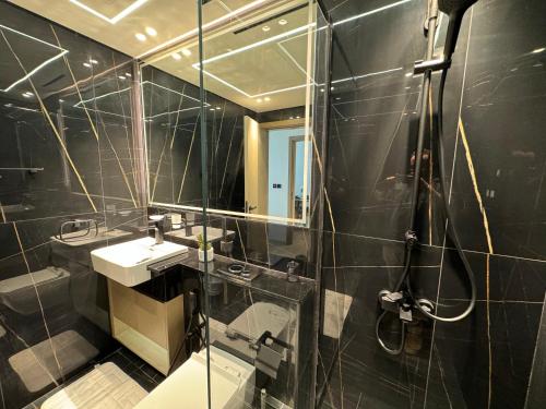 a bathroom with a shower and a sink and a mirror at ASHRI HH, Luxurious Apt in JVC in Dubai
