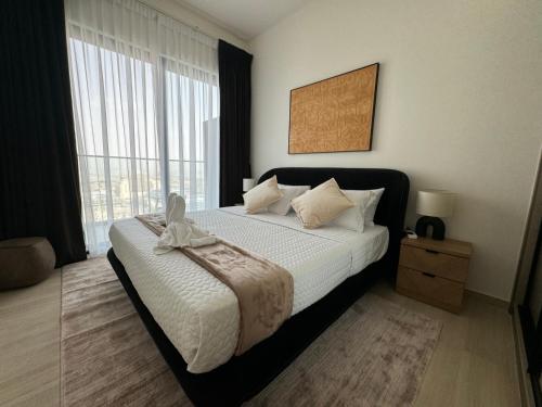 a bedroom with a bed and a large window at ASHRI HH, Luxurious Apt in JVC in Dubai