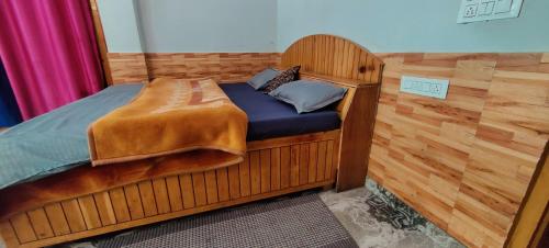a bed in a room with a wooden frame at Flipsyde Retreat in Kasol