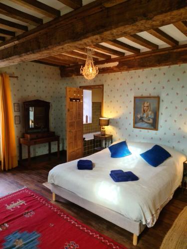 a bedroom with a large white bed with blue pillows at Prieuré saint Léonard, XIème siècle, Baie du mont saint Michel in Vains