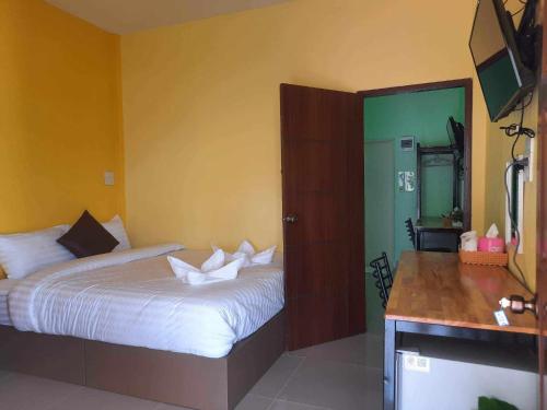 a bedroom with a bed and a green door at ลิตเติ้ลโฮม ที่พักเพชรบุรี in Phetchaburi