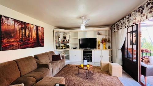 a living room with a couch and a tv at Cantinho Paz e Amor in Nova Petrópolis