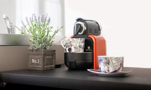 une cafetière assise sur une table à côté d'une usine dans l'établissement Montino - Studio 5 min du circuit - Parking - Wifi, à Mulsanne