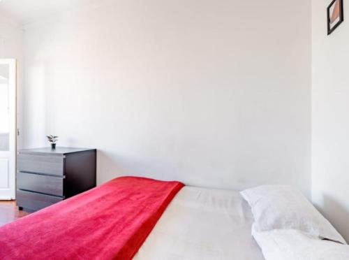 a bedroom with a bed with a red blanket on it at Rigoli House in Lisbon