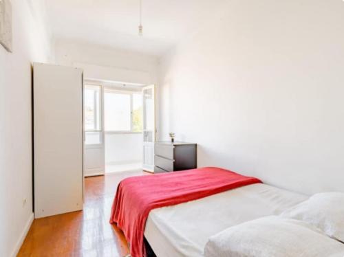a white bedroom with a red blanket on a bed at Colombo Mall Room in Lisbon