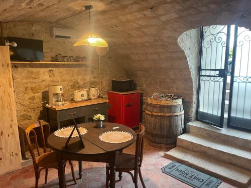 een keuken met een tafel en een wijnvat bij Sous la Glycine in Giverny