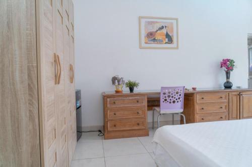 a bedroom with a bed and a desk and a chair at Hotel Azur Conakry in Conakry