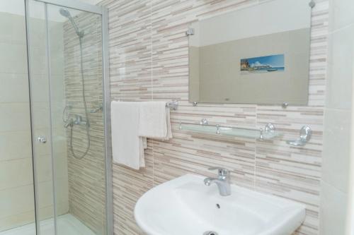 a bathroom with a sink and a shower and a mirror at Hotel Azur Conakry in Conakry