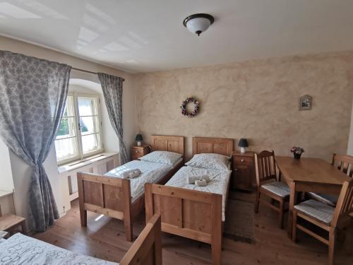 a bedroom with two beds and a table and a dining room at Apartmány U Koudelníka in Kutná Hora