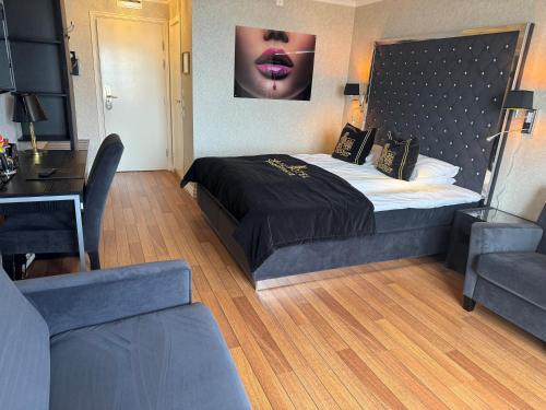 a bedroom with a large bed with a black comforter at Grand Hotel Åsgårdstrand - Unike Hoteller in Åsgårdstrand