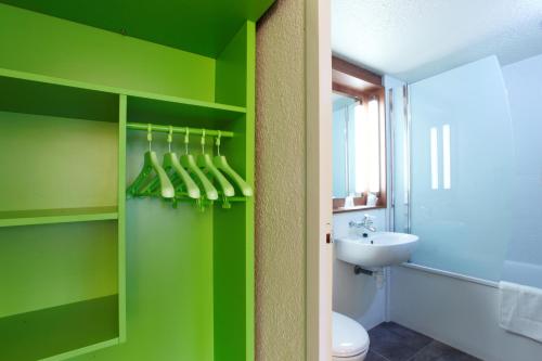 a green bathroom with a toilet and a sink at Campanile Lyon Centre - Gare Perrache - Confluence in Lyon