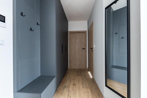 a hallway with glass cabinets and a mirror at Aperto Apartament Gdynia centrum piętro 7 in Gdynia