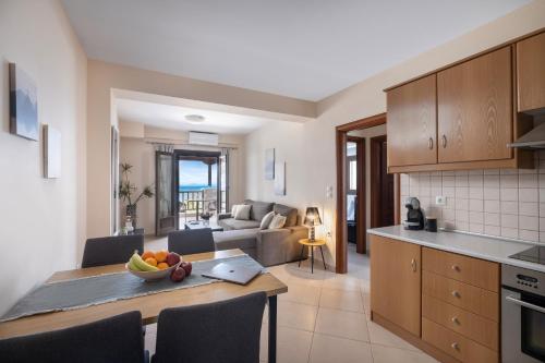 a kitchen and living room with a table with a bowl of fruit at Iakovakis Seaside Exclusive Apartments in Koropi