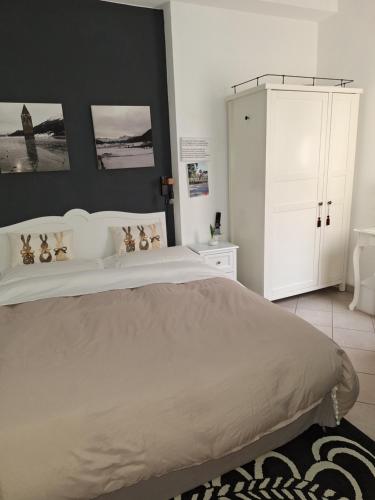 a bedroom with a large bed and a white cabinet at Portico 32 - Merano centro in Merano