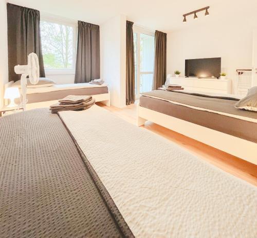 1 Schlafzimmer mit 2 Betten und einem Flachbild-TV in der Unterkunft Home4Now DOR02 Gemütliche Monteursunterkunft in Dormagen in Dormagen