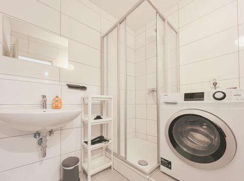 ein Badezimmer mit einer Waschmaschine und einem Waschbecken in der Unterkunft Home4Now DOR02 Gemütliche Monteursunterkunft in Dormagen in Dormagen