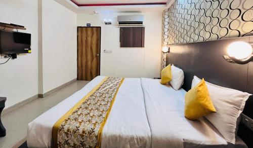 um quarto de hotel com uma cama grande com almofadas amarelas em Hotel Diamond Airport Near TERMINAL 3 em Nova Deli