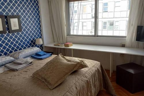 ein Schlafzimmer mit einem Bett vor einem Fenster in der Unterkunft Av.Alvear/Patio Bullrich/Four Seasons Hotel area. in Buenos Aires