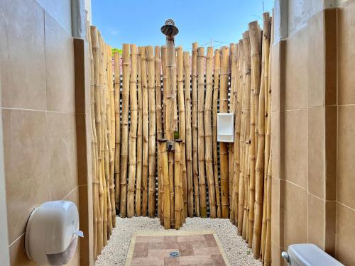 a bathroom with a fence made out of logs at La Tribu in Puerto Viejo
