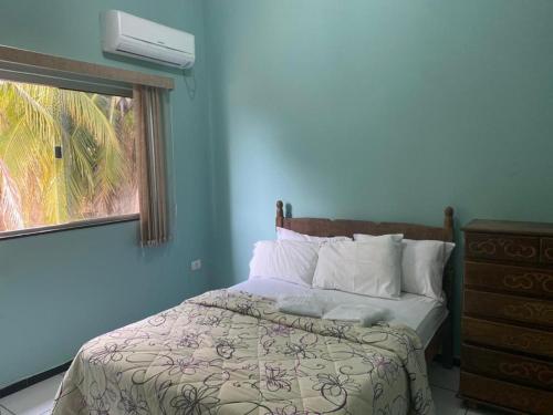 een slaapkamer met een bed en een raam met airconditioning bij Restaurante e Pousada Peruaçu - Cozinha Caseira da Dona Ione in Fabião