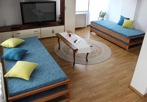 a living room with two beds and a table at The Cosmic Gate Apartments in Visoko