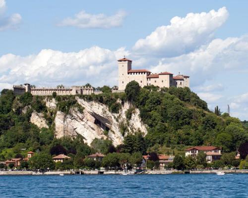 un castillo en la cima de una colina junto al agua en Affittacamere La Quiete en Arona