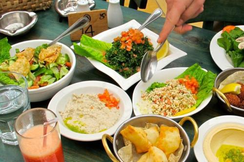 una tavola piena di piatti da mangiare su un tavolo di Jameel Guest House a Tufailah