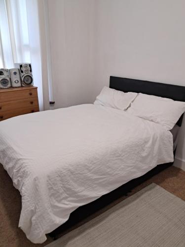 a bedroom with a white bed with a black headboard at New 2BED Kay Road SW9 London in London