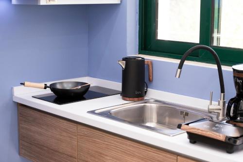 a kitchen counter with a sink and a pot on it at MY PHOS Boutique Apartments in Nikiana