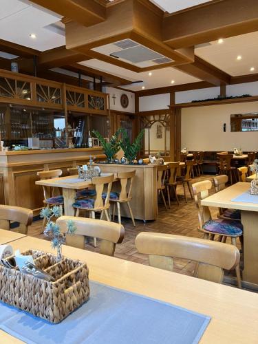 a restaurant with tables and chairs and a bar at Gästehaus Krone in Holzkirchen