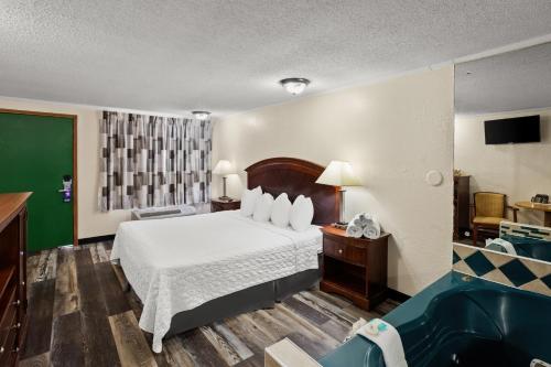 una habitación de hotel con una cama y una bañera en Knights Inn Ashland, en Ashland