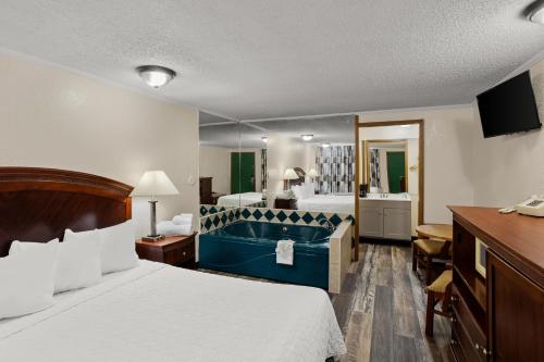 - une chambre d'hôtel avec un lit et une baignoire dans l'établissement Knights Inn Ashland, à Ashland