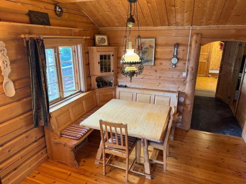 a dining room with a table and chairs in a cabin at Traditional Norwegian log cabin with sauna by the sea in Tornes