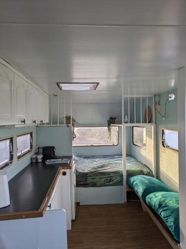 Habitación pequeña con cama y cocina pequeña. en Caravan Zee by BnB de Kapitein, en 't Horntje