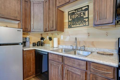 a kitchen with a sink and a refrigerator at Lakeside Cabin with Kayaks Near Cloudland Canyon! in Trenton