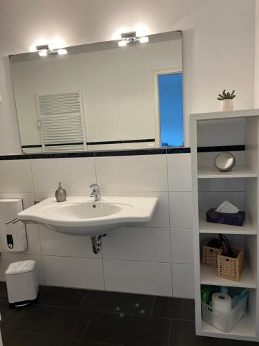 ein Bad mit einem Waschbecken und einem Spiegel in der Unterkunft Haus Meeresbrise in Grömitz