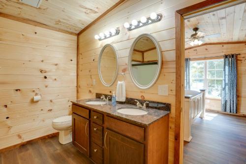 La salle de bains est pourvue de 2 lavabos, de toilettes et d'un miroir. dans l'établissement Lakeside Trenton Cabin on 7-Acre Property!, à Trenton