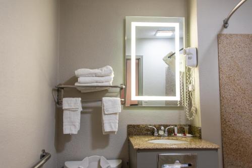 y baño con lavabo y espejo. en Days Inn by Wyndham Troy, en Troy