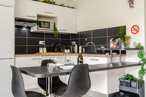 a kitchen with a table and chairs in a room at Paris I 77m Cosy luxe I Near by subway 11 & airport in Bagnolet