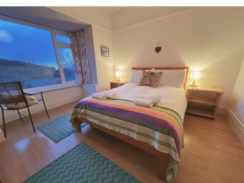 a bedroom with a bed and a large window at Morwelir Llangrannog in Llangrannog