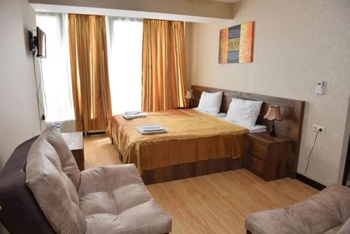 a hotel room with a bed and a couch at Dreamsky hotel in Tbilisi City
