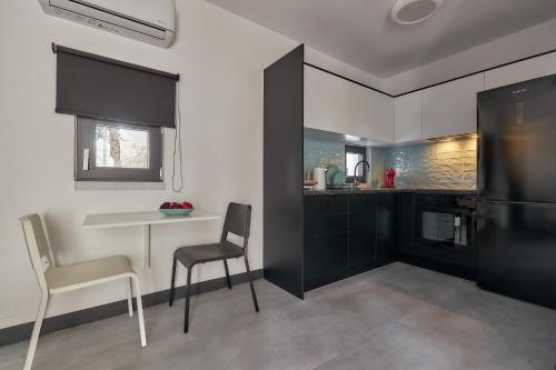 a kitchen with a table and two chairs and a refrigerator at MichELe Luxury apartments by Smaris Collection in Malia