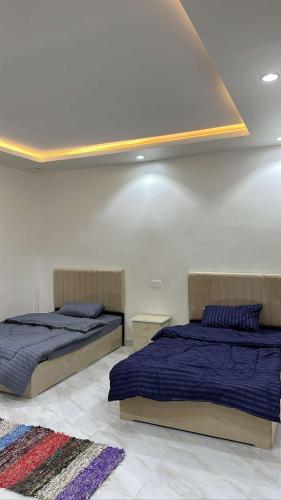 2 bedden in een witte kamer met: bij نيوم سيتي in Al Bad‘
