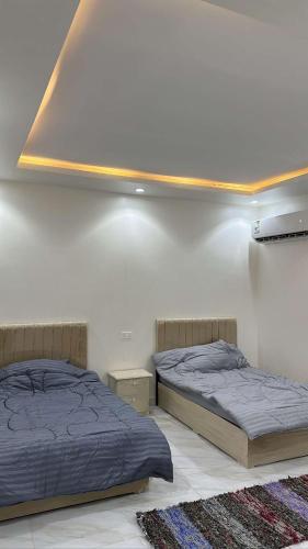 twee bedden naast elkaar in een slaapkamer bij نيوم سيتي in Al Bad‘